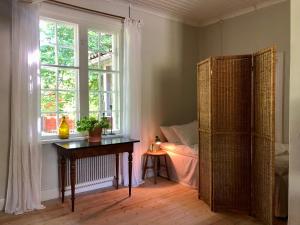BorgvikBorgviks herrgårdsflygel的一间卧室配有桌子、窗户和床。