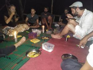 武吉拉旺Bukit Lawang Glamping & Jungle Trekking的一群坐在桌子旁吃食物的人