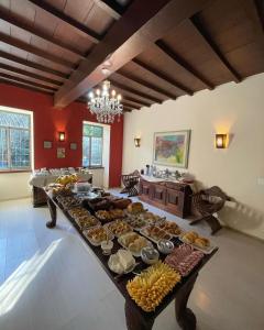 伊泰帕瓦Pousada Cozy House的长桌,长桌里放着不同种类的食物