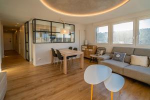 布尔戈斯Alfonso X - Apartamentos Burgos Deluxe的客厅配有沙发和桌子