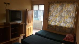 科恰班巴Concordia - Hospedaje的客房设有电视、床和窗户。