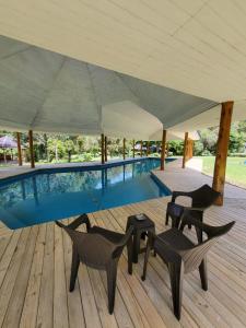 普尤瓦比港El Pangue Lodge的一个带椅子和桌子的帐篷下的游泳池