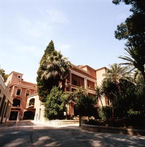 阿尔切纳巴尔尼尔里奥阿尔切纳莱昂酒店的街道前方有棕榈树的建筑