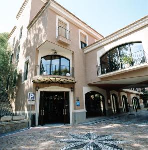 阿尔切纳巴尔尼尔里奥阿尔切纳莱昂酒店的一座带门和阳台的大型建筑