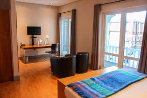 开普敦Hippo Boutique Hotel的一间卧室配有一张带书桌的床和窗户。