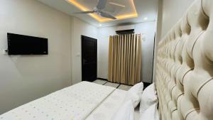 伊斯兰堡Hotel Double1的一间卧室配有一张床和一台平面电视