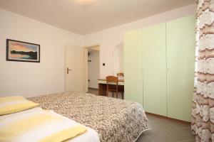内里吉恩Apartment Nerezine 2518c的一间卧室配有一张床和一张书桌