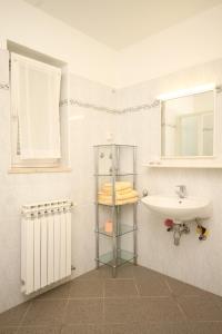 内里吉恩Apartment Nerezine 2518c的一间带水槽、卫生间和镜子的浴室