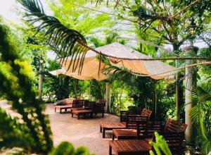 怡保EFM GREENLAND IPOH的庭院设有木长椅和遮阳伞