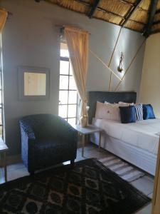 范德拜尔帕克Matlapeng Country Estate的一间卧室配有一张床、一张沙发和一张桌子