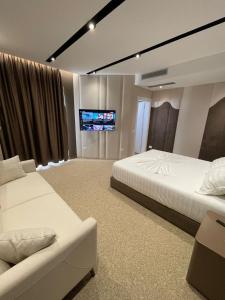 伏罗拉Hotel PortSide GF的一间卧室配有两张床和一台平面电视
