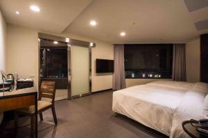 平镇日月光国际饭店桃园馆的酒店客房配有一张床、一张书桌和一张书桌。