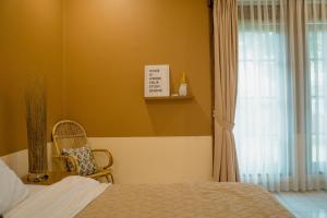 万隆Roemah Renjana Bandung的卧室配有床、椅子和窗户。