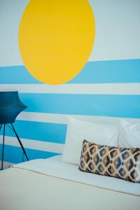 万隆Roemah Renjana Bandung的卧室配有一张墙壁上黄色圆圈的床