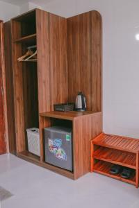 洞海Vagibi Hotel的一间客房内的木制橱柜,内配冰箱