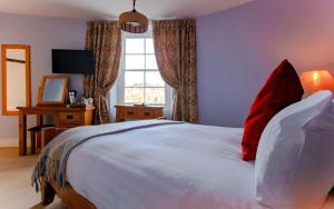达特茅斯The Ship in Dock Inn的卧室配有带红色枕头的大型白色床