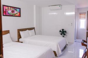 洞海Vagibi Hotel的白色墙壁客房的两张床