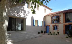卡瓦永Domaine Les Rivales的白色的建筑,设有蓝色的门和楼梯