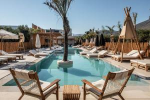 赫索尼索斯Indigo Inn Casa Adults Only的一个带躺椅的游泳池,并种植了棕榈树