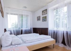 尼尔堡Ringhaus - Home of Silver Arrows的一间卧室配有一张带白色床单的床和一扇窗户。