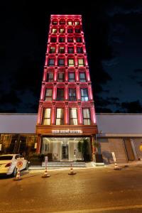 伊斯坦布尔THE HUBİ HOTEL的一座高楼,楼前有一座红色的塔