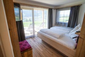 丘萨Chalet am Wiesenweg的一间卧室设有一张床和一个大窗户