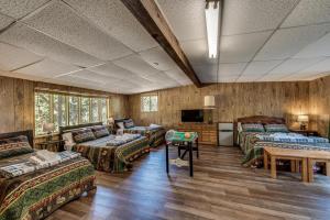 格罗夫兰Pet Friendly Grizzly Blair Lodge Cabin的一间设有四张床、一张沙发和一张桌子的房间