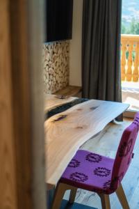丘萨Chalet am Wiesenweg的木桌和紫色椅子