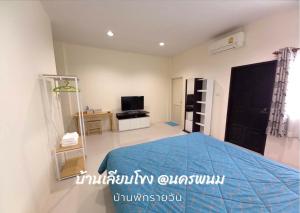 Ban Nong Pukบ้านเลียบโขง@นครพนม的一间卧室配有蓝色的床和电视