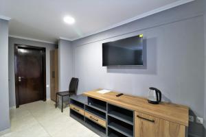 第比利斯Hotel Rose的客房设有书桌和墙上的电视。