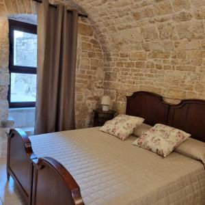 阿尔贝罗贝洛La tana degli Incerti的卧室配有砖墙内的床铺