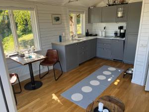 韦姆德Exclusive guesthouse with stunning Seaview!的厨房配有灰色橱柜、桌子和桌子。