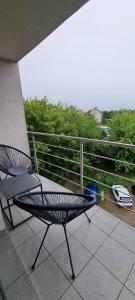 什奇特诺Apartament Szczytno - Centrum的一张黑椅,坐在带围栏的阳台