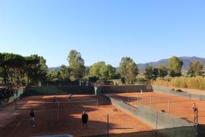卡斯蒂里昂纳·德拉佩Tennis Rocchette Resort的一群人在网球场打网球