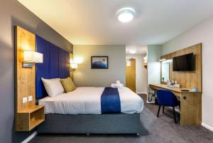 沃里克戴斯沃里克北界M40酒店的配有一张床和一张书桌的酒店客房