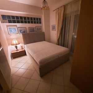 新马克立piu verde1的卧室配有一张床和一盏灯,铺有瓷砖地板。