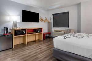 JeromeSleep Inn & Suites的配有一张床和一台平面电视的酒店客房