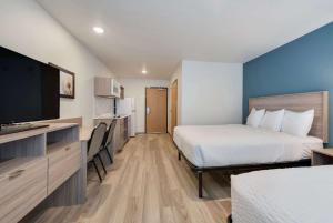 默里迪恩WoodSpring Suites Meridian的酒店客房设有两张床和一台平面电视。