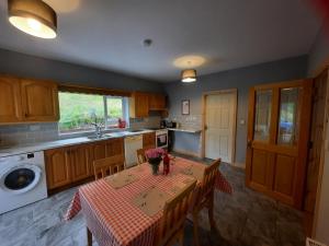 克利夫登Conneelys Cottage, Connemara, Clifden, H71Y096的厨房配有桌子和桌布