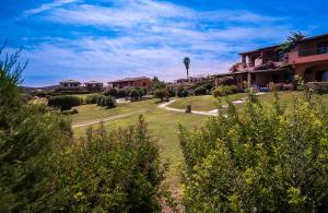 阿兰奇湾城Appartamenti Marineledda Golfo di Marinella的享有带房屋和树木的庭院的景色
