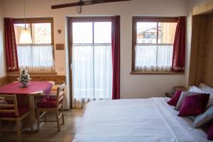 瓦尔迪佐多Residence Valpiccola的卧室配有床、桌子和窗户。