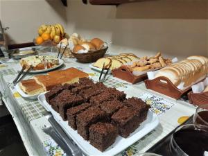 卡内拉Pousada Bella Serra的餐桌上摆放着不同种类的面包和甜点