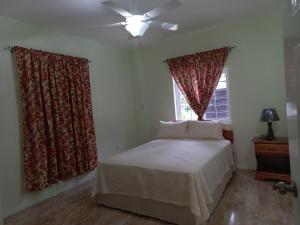尼格瑞尔Stoney Gate Cottages的一间卧室配有床和带窗帘的窗户