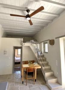 基莫洛斯岛Fournos的客厅配有吊扇、桌子和楼梯