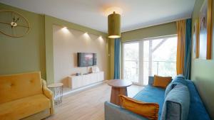 卡尔帕奇Apartamenty EverySky - Słowackiego 5a-b的客厅设有蓝色的沙发和窗户。
