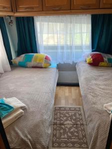 辛尼莫雷特Синеморец Каравана Paradise的带窗户的客房内的两张床