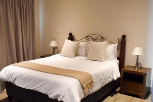 波特里弗Arcangeli Wines的卧室配有一张带白色床单和枕头的大床。