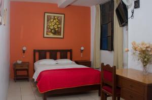 皮乌拉圣何塞酒店的一间卧室配有一张橙色墙壁的床