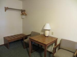 卡斯特Chief Motel的配有桌椅和台灯的房间