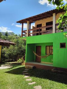 韦尔卡鲍Pousada Abacateiro的绿色白色的房子,有院子
